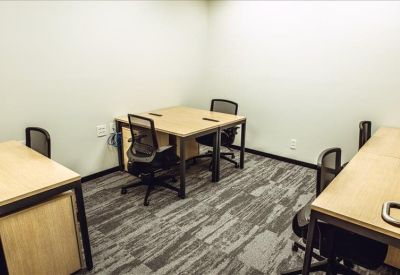 Four-person private office suite with light wood desks.