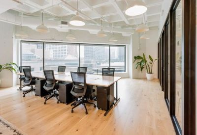 Modern meeting room with a large table, mesh chairs, and floor-to-ceiling windows.