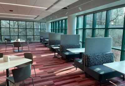 Bright dining area with booth seating and floor-to-ceiling windows.