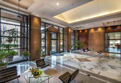 Spacious building lobby featuring marble floors, high ceilings, and plush seating.