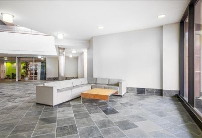 Spacious lobby area with slate tile flooring and a minimalist white sofa.