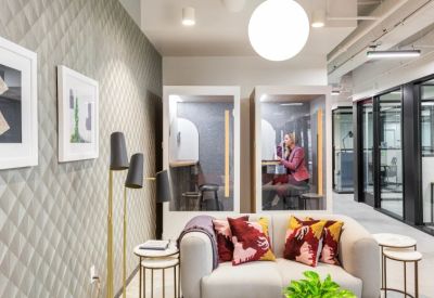 Cozy lounge area with a plush sofa, decorative pillows, and private acoustic phone booths.