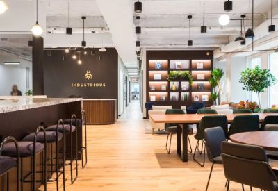 Spacious reception area featuring a branded desk, lounge seating, and modern lighting.