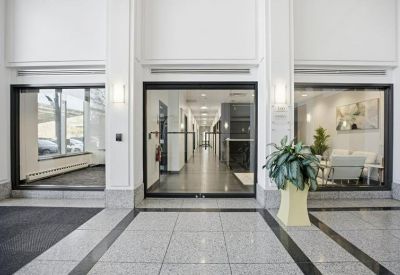 Modern building lobby with sleek stone tile flooring and glass entrance doors.