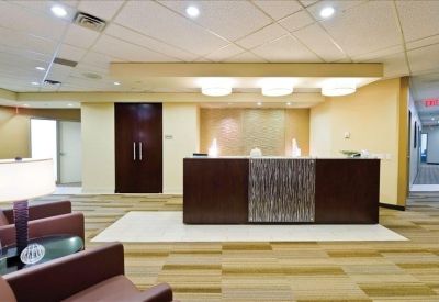 Professional reception desk with wood finishes and soft overhead lighting.