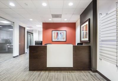 Reception area featuring a dark wood front desk and a terracotta feature wall with art.