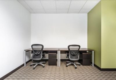 Private internal office featuring two desks and a green accent wall.