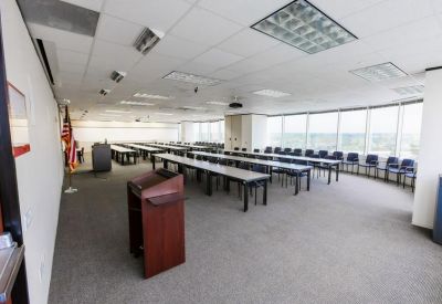Spacious training room with rows of long tables and chairs.