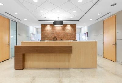 Modern reception area with a wood-fronted desk and recessed ceiling lighting.