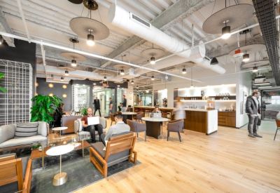 Large open-concept lobby with diverse seating, a coffee station, and high ceilings.