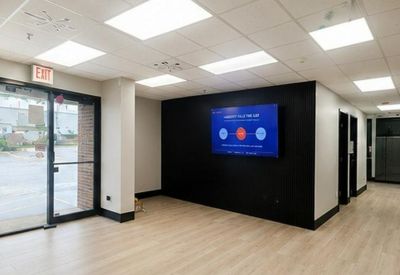 Entrance lobby with a black feature wall and wall-mounted digital display.