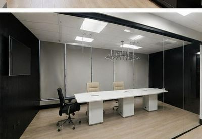 Modern conference room with a long white table and frosted glass partitions.