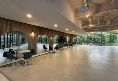 Spacious communal lounge area with wood-paneled walls, arched mirrors, and modern dining furniture.