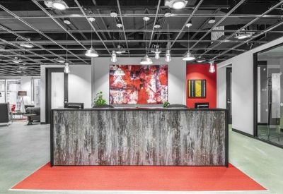 Modern reception desk with a textured wood-panel front and red floor mat.