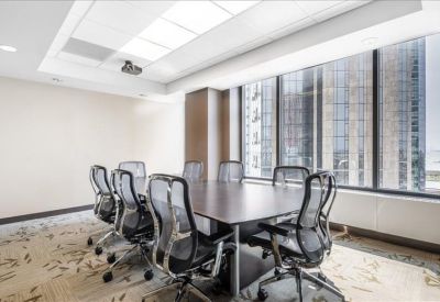 Sleek office kitchen with dark cabinetry, white countertops, and stainless steel appliances.
