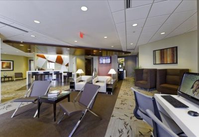 Spacious reception lobby with a coffee station, comfortable seating, and patterned carpeting.