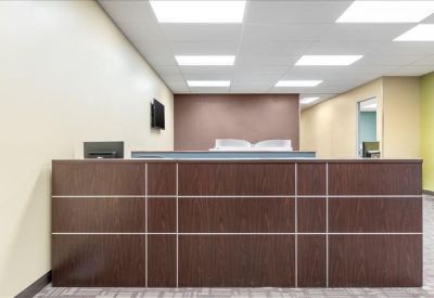 Reception area featuring a dark wood front desk and a feature wall in the background.