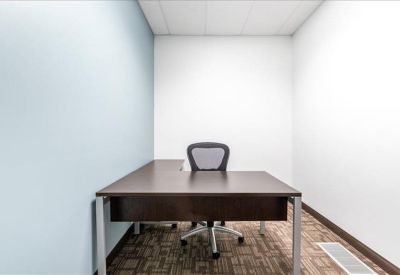 Private office suite featuring an L-shaped dark wood desk and a blue accent wall.