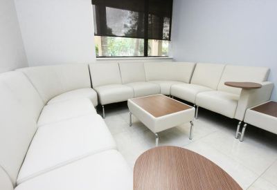 Comfortable lounge area with white leather sectional seating.