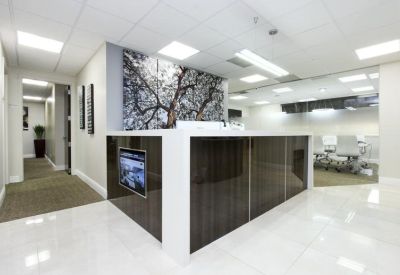 Modern reception desk with a large tree-mural feature wall.