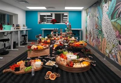 Close-up of a catering spread on a long table against a tropical wildlife mural.