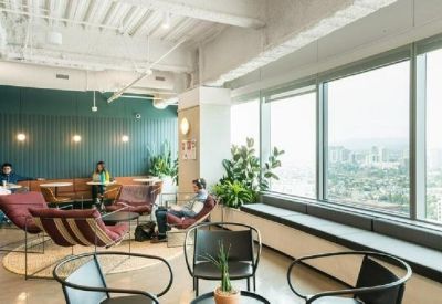Lounge area with mid-century modern armchairs and large windows overlooking the city.