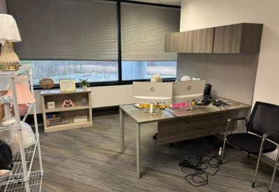 Office room featuring dual desktops and shelves.