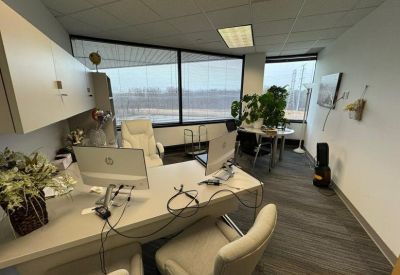 Spacious office with large windows and potted plants.