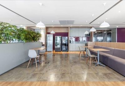 Vibrant communal kitchen and break area with indoor plants and purple wall accents.