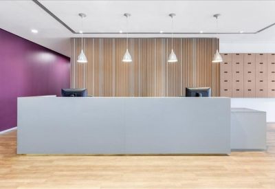 Modern reception area featuring a grey desk, wooden accent wall, and purple feature wall.