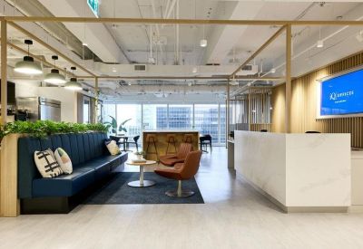 Reception area featuring a sleek white front desk, blue sofa lounge, and wooden frame partitions.