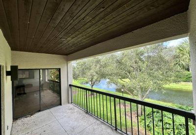 Covered balcony overlooking a lush green landscape and a peaceful waterway.