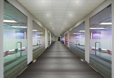 Long office corridor with glass-walled private suites and recessed lighting.