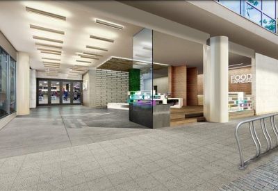 Spacious open lobby with a minimalist front desk and industrial-style ceiling lights.