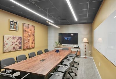 Large conference room featuring a wood table, leather chairs, and two large pieces of abstract art.