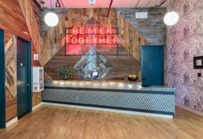 Reception area featuring a wood-paneled wall with a neon Better Together sign.