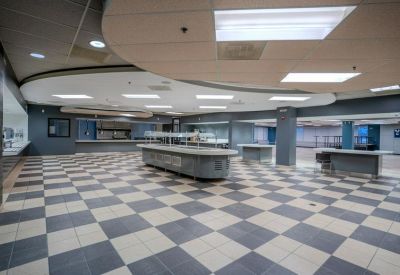 Spacious cafeteria area with checkered flooring and built-in service counters.