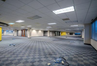 Wide empty office suite featuring large windows and visible floor power outlets.