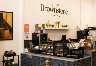 Cafe service counter with slate grey tiling and overhead track lighting.