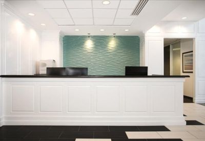 Elegant white reception desk set against a textured teal feature wall.