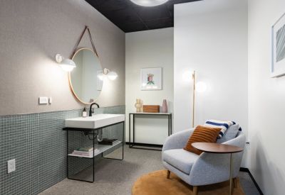 Wellness room or lounge featuring a plush armchair, circular mirror, and calming decor.