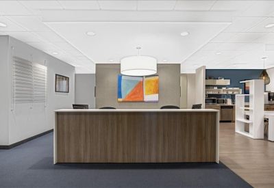 Reception area featuring a wood-fronted desk and colorful abstract painting.