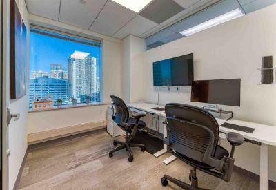 Sleek internal office with a large monitor and white standing desk.