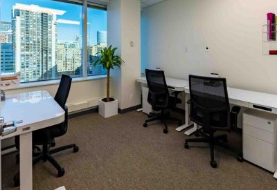 Efficient workspace with a small potted plant and city skyline views.