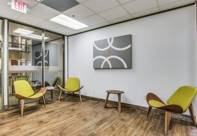 Lounge area featuring lime green wingback chairs and modern wall art.
