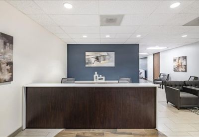 Reception area featuring a dark wood front desk against a navy blue accent wall.