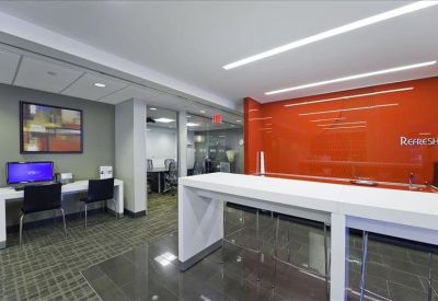 Contemporary breakout area with vibrant orange feature wall and a high-top communal table.