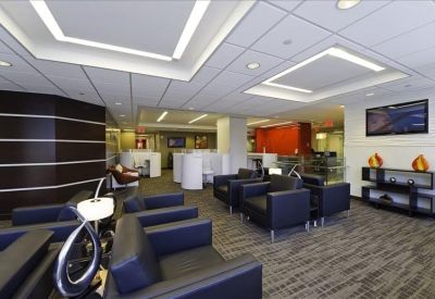 Spacious waiting area with dark leather armchairs and contemporary wall paneling.