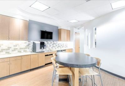 Modern communal kitchen and break area with a large island and coffee station.