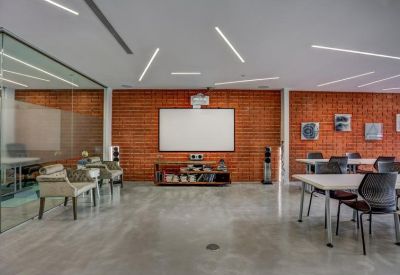 Open-plan office featuring brick accent walls and a projection screen.